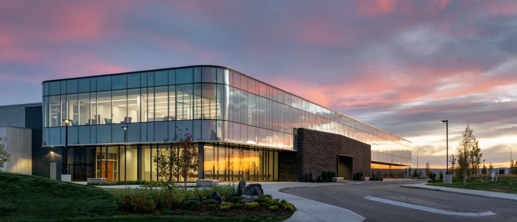 Modern medical isotope facility exterior at dusk